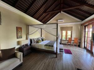 a bedroom with a canopy bed and a couch at Boutique hotel villa Cantik and karma beach club in Uluwatu +68 photos