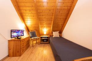 a room with a bed and a tv and a chair at Ferienhaus Vogelsand 08 in Dorum-Neufeld