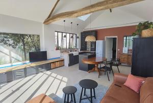 a kitchen and living room with a couch and a table at Maison Félice in Les Ageux