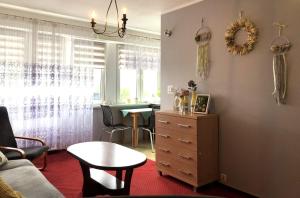 a living room with a dresser and a table and a dining room at Kawalerka EKOLOR in Konin