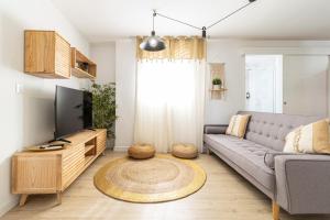 un salon avec un canapé et une télévision dans l'établissement AdEva Céntrico 3 Habitaciones, à Jerez de la Frontera