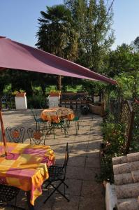 a patio with tables and chairs under a canopy at Maison d'hôtes et Campement Mariposa in Lanne