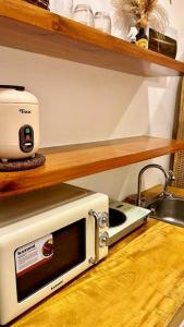 a microwave sitting on a counter next to a sink at Bohemian Moderns Style Living- Free Pool- Pet Friendly in Manila