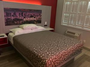 a bedroom with a bed with a large poster of a city at Playa Inn Motel - Long Beach, LA in Long Beach
