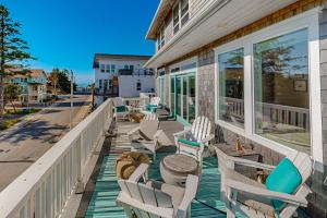 a porch with chairs and a table and windows at Pacific Breeze in Lincoln City