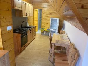 una cocina con una mesa y una estufa en Domek na Stasince, en Sidzina