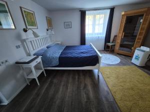 a bedroom with a bed and a table and a window at Ötbárány Vendégház in Bezeréd