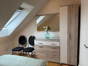 a bedroom with a bed and two chairs at Grenzblick in Isselburg-Anholt in Isselburg