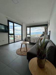 Un dormitorio con una cama, una mesa y un sofá. en Penguins Flats 2, en Ushuaia