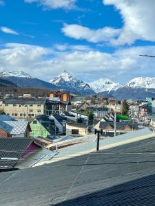 una ciudad con montañas cubiertas de nieve en el fondo en Penguins Flats 2, en Ushuaia