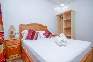 a bedroom with two beds and a night stand with a lamp at Casa Medina in Chefchaouene