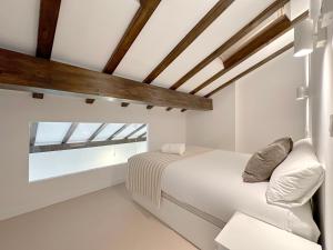 a bedroom with a white bed and a window at Duplex con vistas a Santa María in Castro-Urdiales