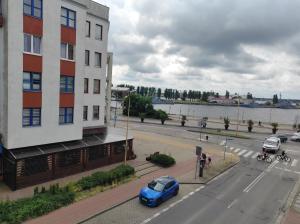 a blue car parked on a street next to a building at Swineminde Polen Apartament Haffen blick bitte anrufen in Ahlbeck