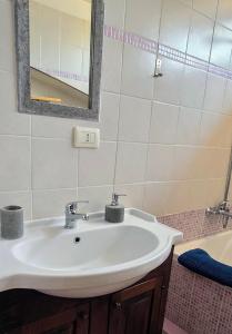 une salle de bains avec un lavabo blanc et un miroir dans l'établissement Un sacco di vento, à Marino 19 autres photos