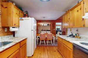 a kitchen with a white refrigerator and a dining room at Alpine Lodge in Salem