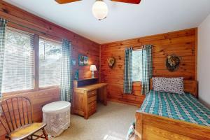 a bedroom with wooden walls and a bed and a desk at Alpine Lodge in Salem
