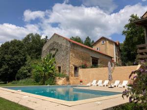 a house with a swimming pool next to a building at Gîte de charme La Pradelle in Prats-du-Périgord