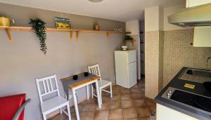 une cuisine avec une table, des chaises et un réfrigérateur dans l'établissement Un sacco di vento, à Marino