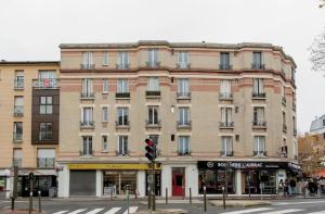 a large brick building on a city street with a traffic light at Charmant Appartement Cosy à Suresnes in Suresnes