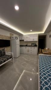 a large kitchen with white cabinets and a couch at Villa Burçin Apart in Dalyan
