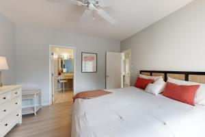 a bedroom with a large white bed with red pillows at Spring Lake --- 38167 West Dr. #716 in Rehoboth Beach