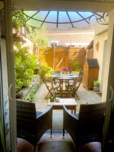 a patio with a table and chairs in a garden at Maison de charme d'Ile de France in Chaumontel