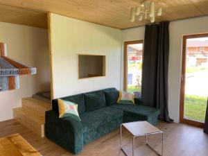 a living room with a green couch and a table at Haus 7&50 in Bolsterlang
