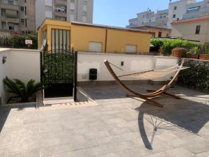a hammock on a patio with a building at Appartamento Massimo in Nettuno