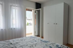 a bedroom with a bed and a large window at Vesa Apartments in Peje