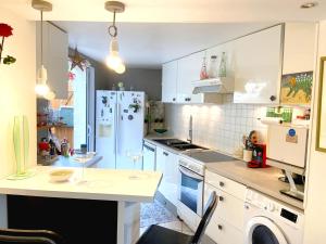 a kitchen with white cabinets and a white refrigerator at Maison de charme d'Ile de France in Chaumontel +5 photos