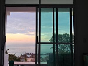 a view of the ocean from a window at Casa la xulada in Mazunte
