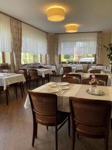 a dining room with tables and chairs and windows at Villa Daheim in Borkum
