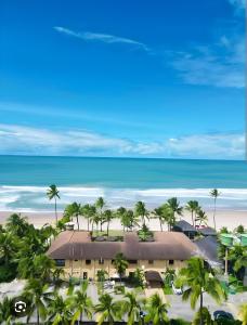 una vista aerea di un resort con palme e spiaggia di Lazer - Flat Condomínio Muro Alto Clube a Porto De Galinhas