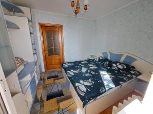 a bedroom with a bed with a black and white comforter at Отдельная комната in Sectorul Botanica +2 photos