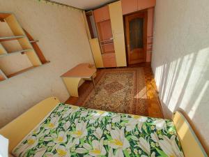 a room with a bed with flowers on it at Отдельная комната in Sectorul Botanica