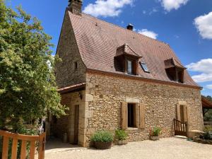 a large stone building with a roof at Gîte de charme La Pradelle in Prats-du-Périgord