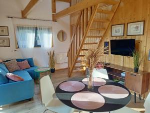 a living room with a table and a blue couch at Słoneczne Mazury - Dom Wakacyjny in Piasutno