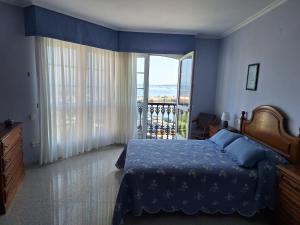 a bedroom with a bed and a large window at Piso Beiramar O Grove in O Grove