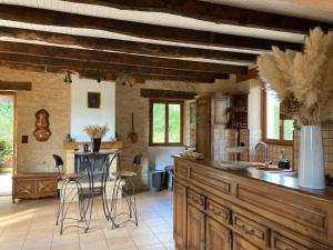 a kitchen with wooden cabinets and a counter with stools at Gîte de charme La Pradelle in Prats-du-Périgord