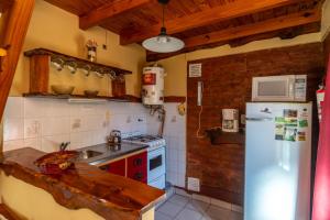 a kitchen with a refrigerator and a sink at Cabañas Rayun in Villa Ventana