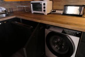 a kitchen counter with a microwave and a washing machine at Résidence Oucanes - Superbe T3 avec accès direct aux pistes de Réallon OUC7 MAE-8401 in Réallon +6 photos