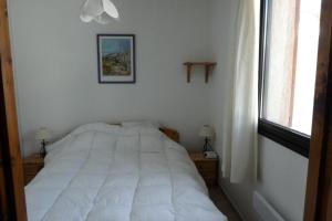 a white bed in a bedroom with a window at Résidence Oucanes - Superbe T3 avec accès direct aux pistes de Réallon OUC7 MAE-8401 in Réallon
