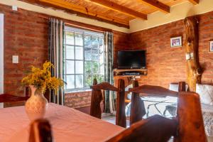 Una habitación con una mesa con un jarrón de flores. en Cabañas Rayun, en Villa Ventana 8 fotos más