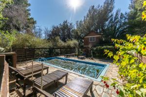 una piscina con 2 sillas y un banco en Cabañas Rayun, en Villa Ventana