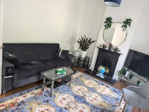 a living room with a couch and a table and a fireplace at wallington double Room in Hackbridge