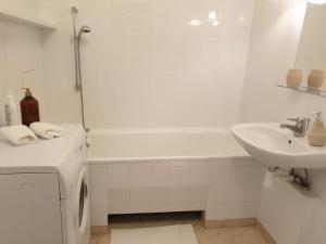 a white bathroom with a tub and a sink at Mieszkanie dla całej rodziny in Łódź +10 photos