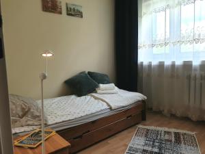 a small bedroom with a bed with a window at Mieszkanie dla całej rodziny in Łódź