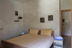 - une chambre dotée d'un lit avec des draps blancs dans l'établissement Agriturismo Maso Rocca, à Ala