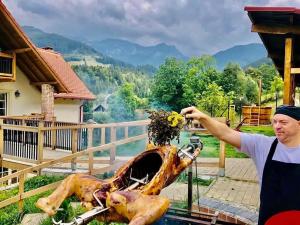 a man in an apron standing next to a statue of a dog at The Lodge Transylvania in Bran