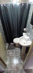 a bathroom with a black shower curtain and a toilet and sink at jazmin apart iguazu in Puerto Iguazú